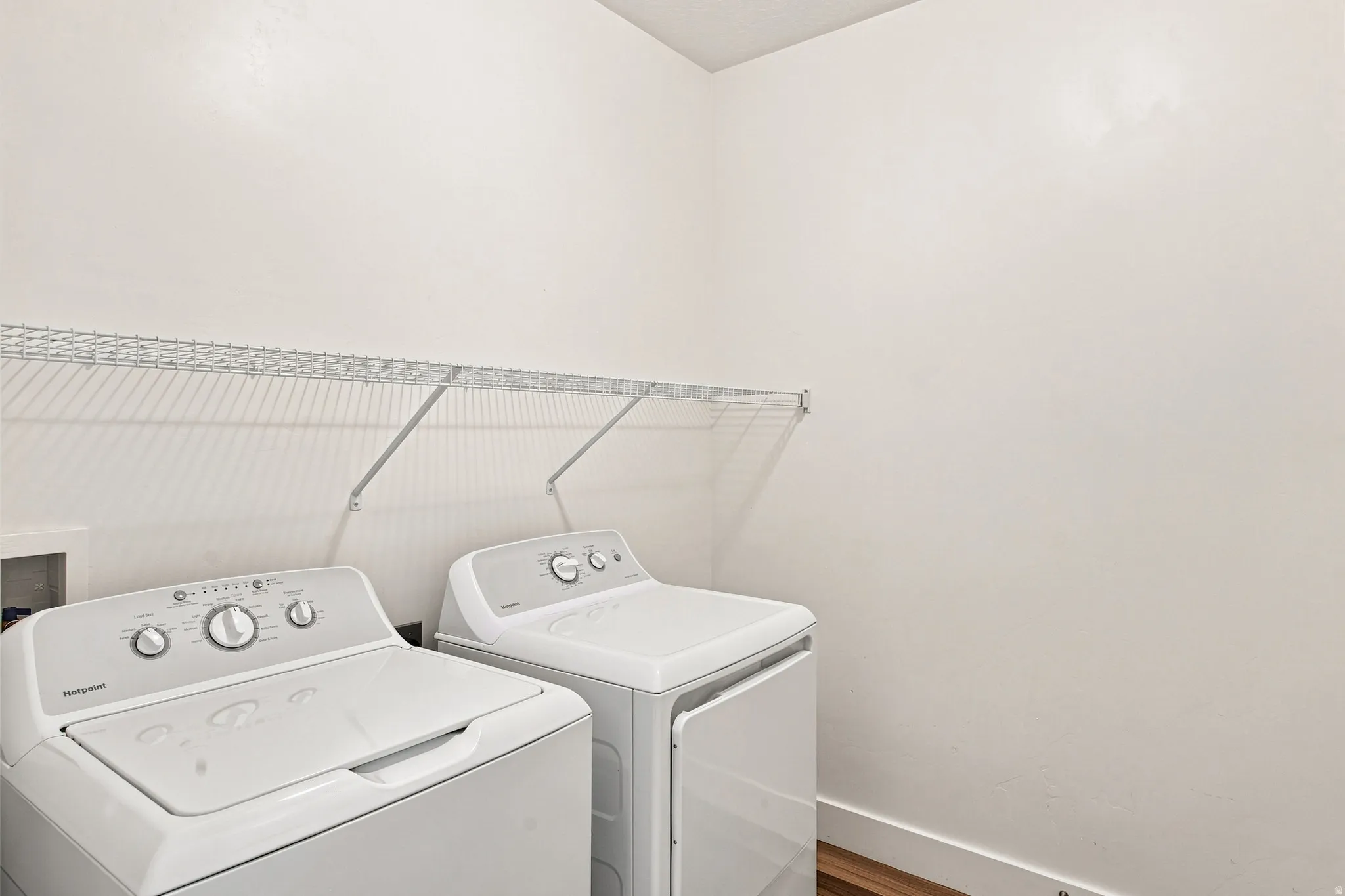 Dedicated laundry area featuring a wire shelving unit