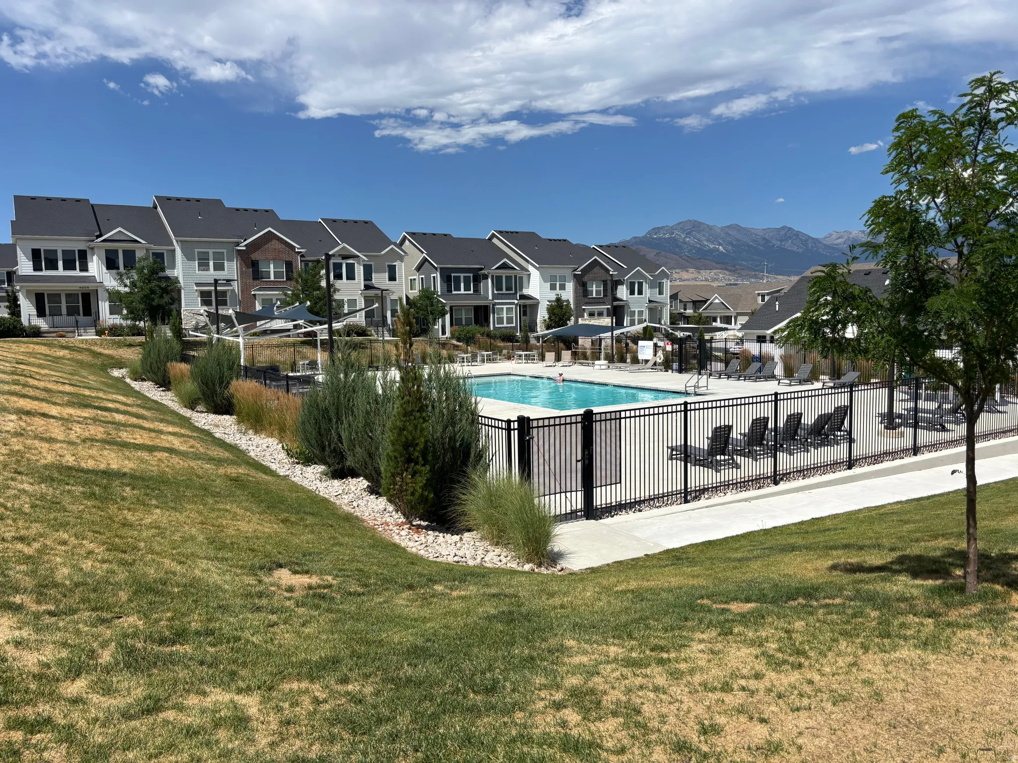 Outdoor swimming pool with surrounding black metal fencing