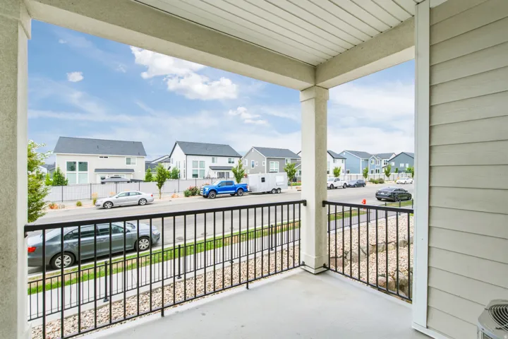 Covered porch with concrete flooring and a black metal railing