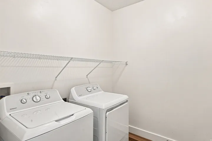 Dedicated laundry area featuring a wire shelving unit