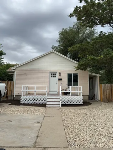 Single-story residence featuring light-colored siding and a gable roofline