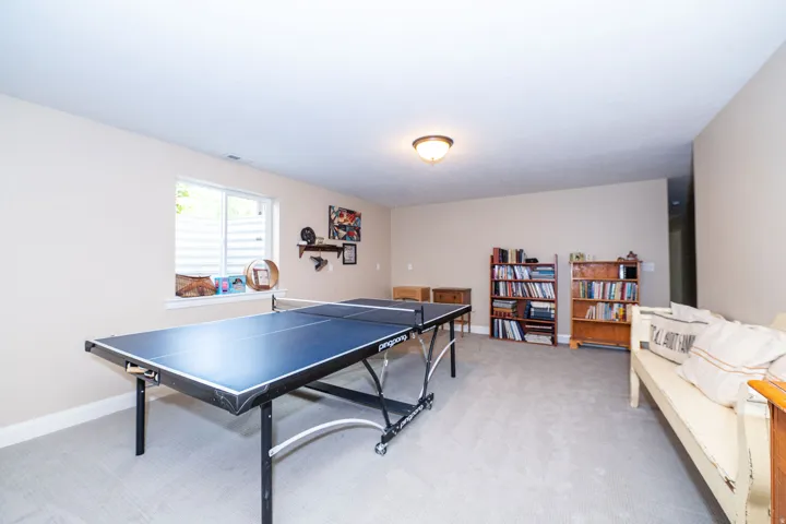 Spacious lower-level room featuring light-toned carpeting and neutral wall tones