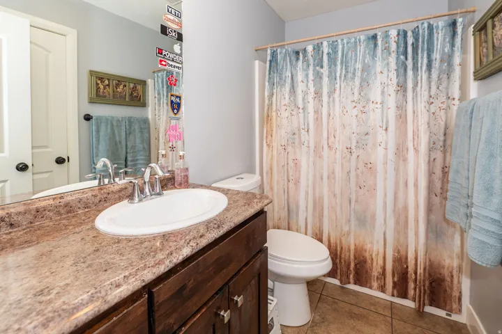 Bathroom featuring a vanity with an oval sink, chrome faucet, and stone-finish countertop