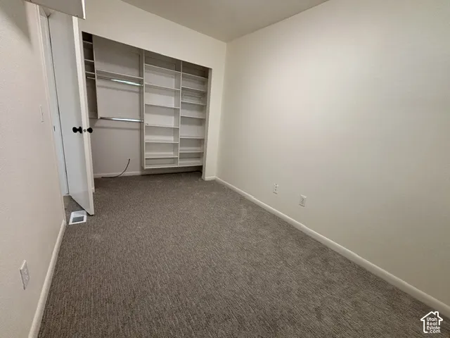 Wall-to-wall carpeting and built-in closet shelving with hanging rods
