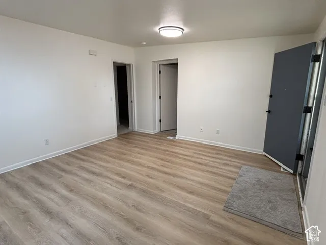 Neutral white walls, wood-finish flooring, and flush-mount ceiling lighting