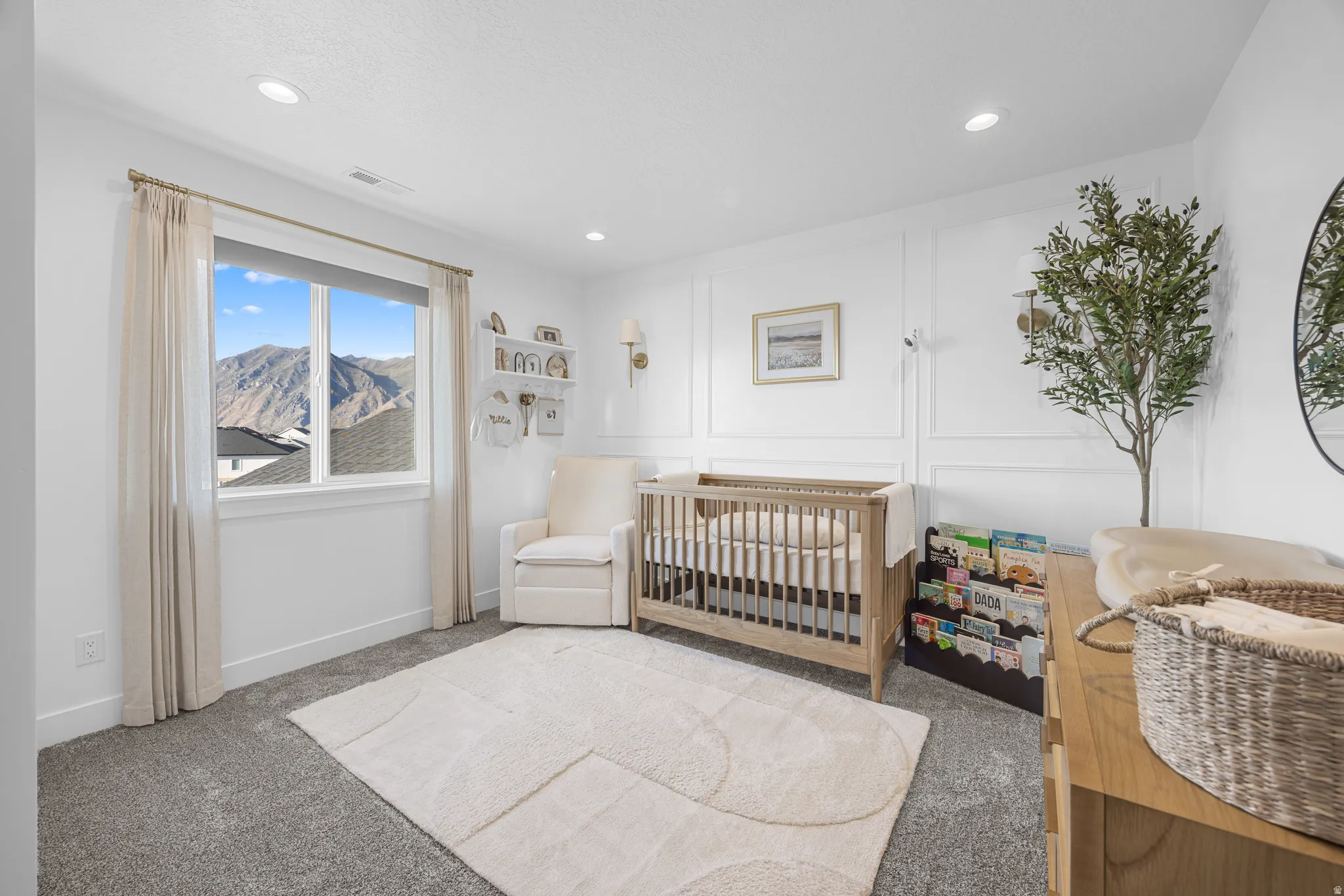 Spacious room featuring a large window with mountain scenery, recessed lighting, and wall paneling