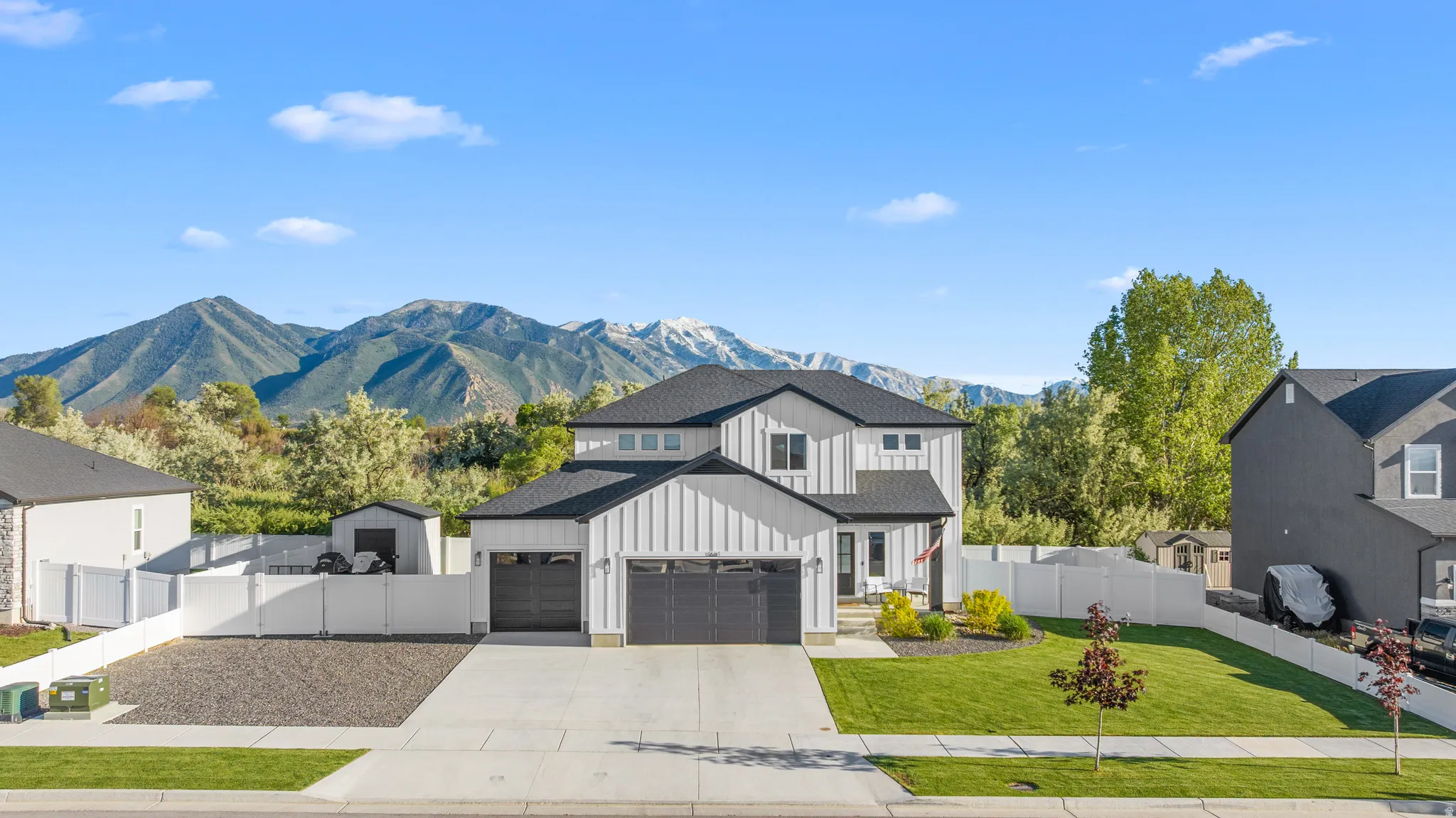 Modern two-story home featuring a white vertical board and batten facade and black trim