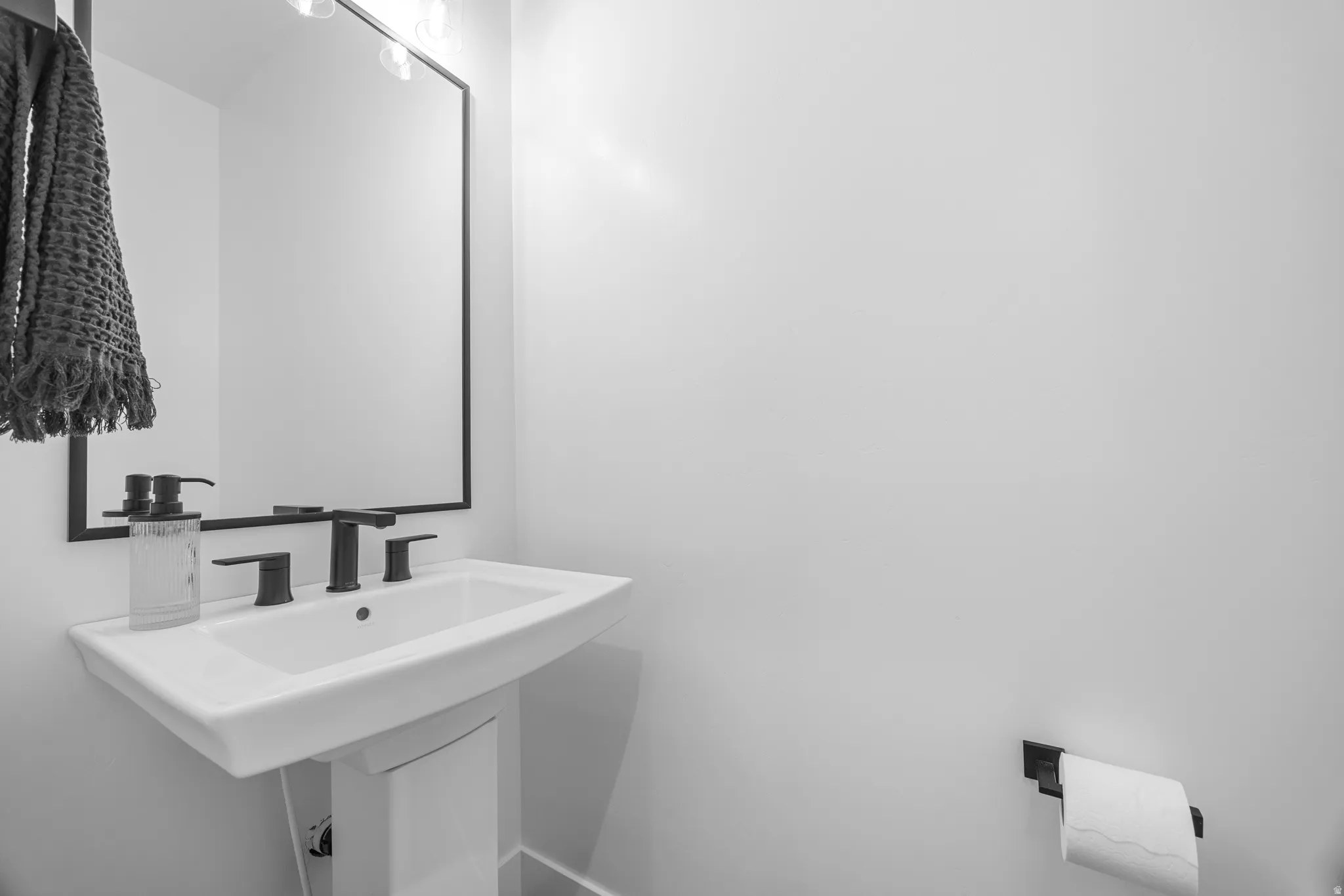 Pedestal sink featuring a rectangular basin and matte black fixtures