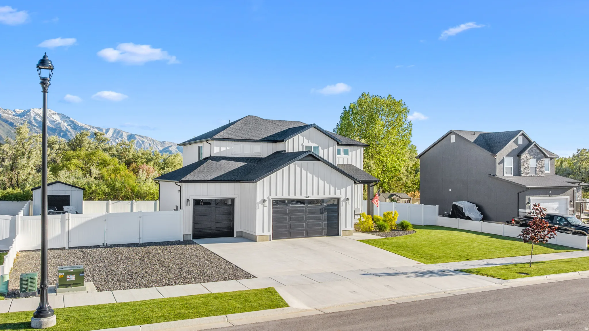 Contemporary two-story residence featuring a white vertical siding exterior and dark roofing