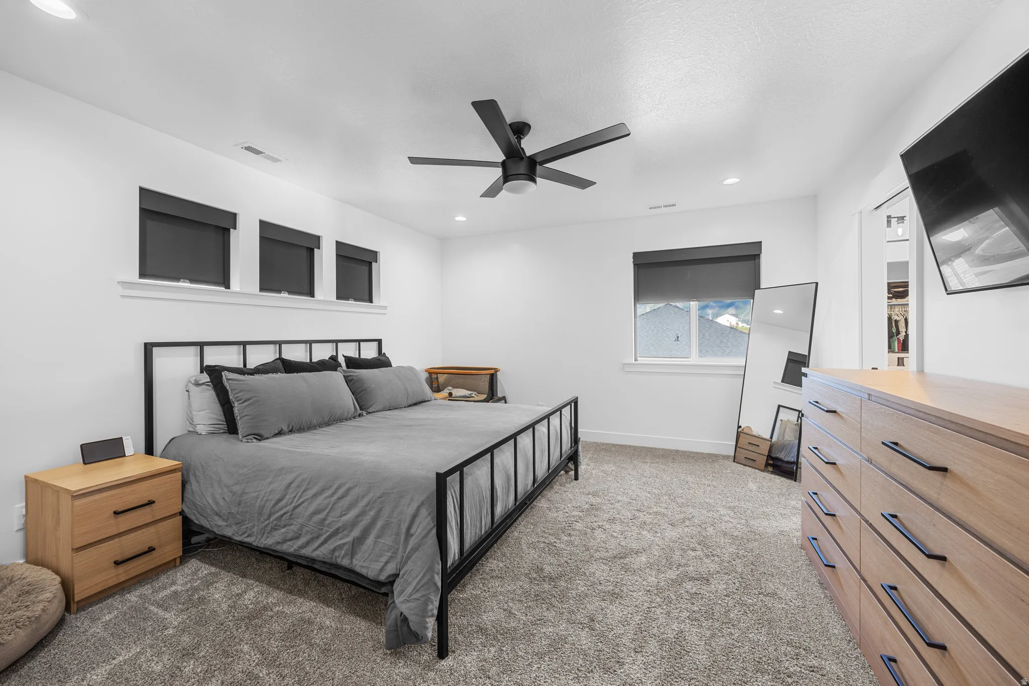 Spacious room featuring light-colored walls, recessed lighting, and a ceiling fan