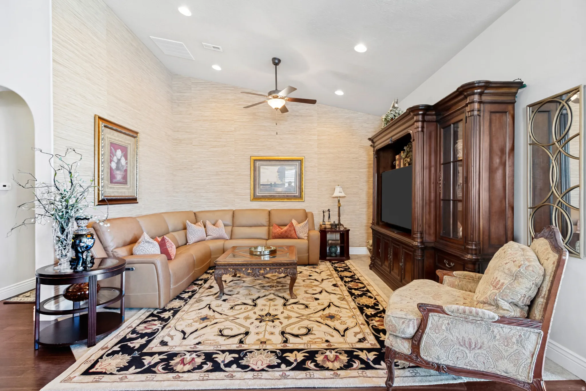 Living area featuring vaulted ceilings, recessed lighting, wood-finish flooring, and textured wall coverings