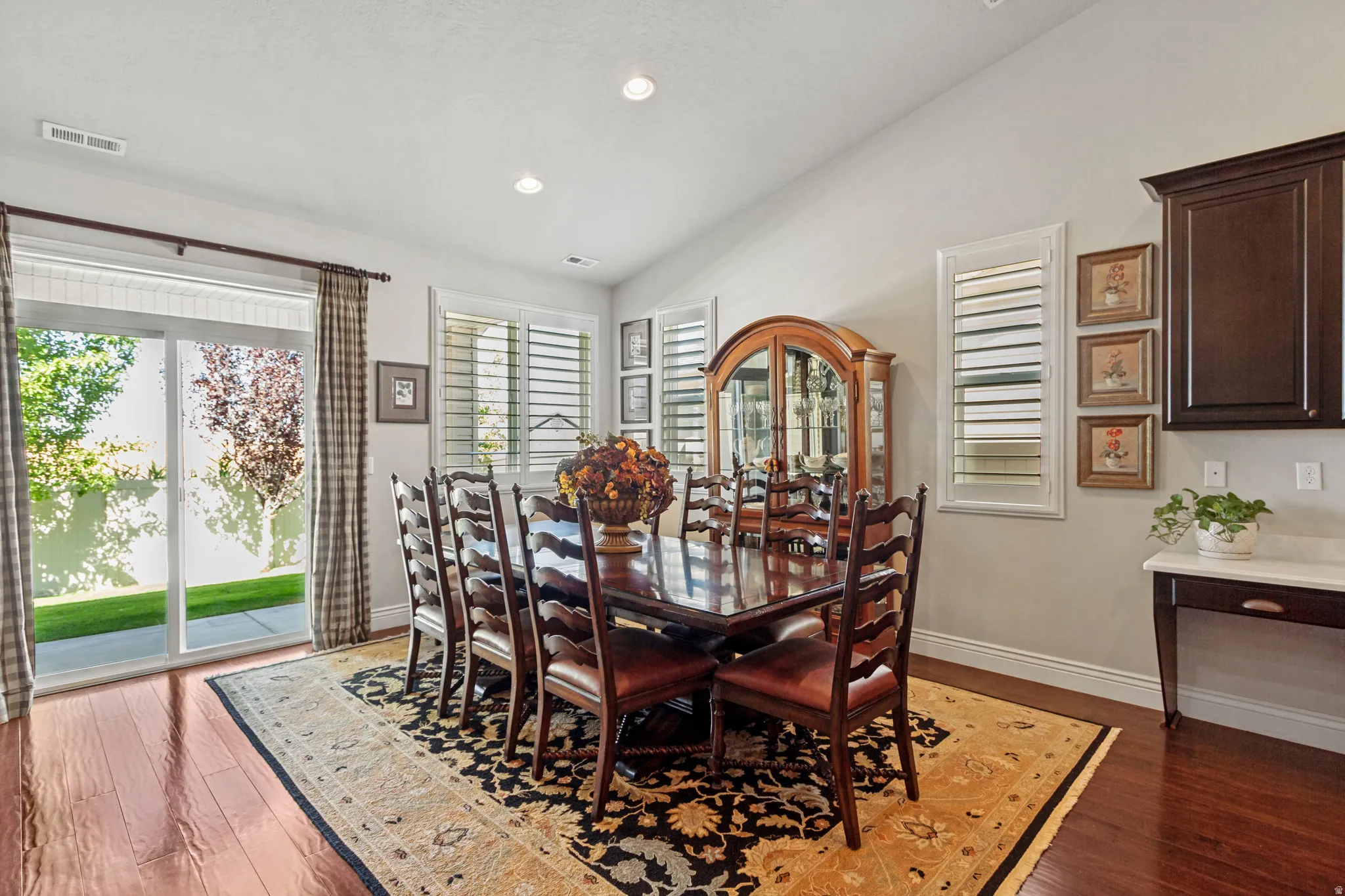 Formal dining area with wood-finish flooring, recessed lighting, and patio access via sliding glass doors