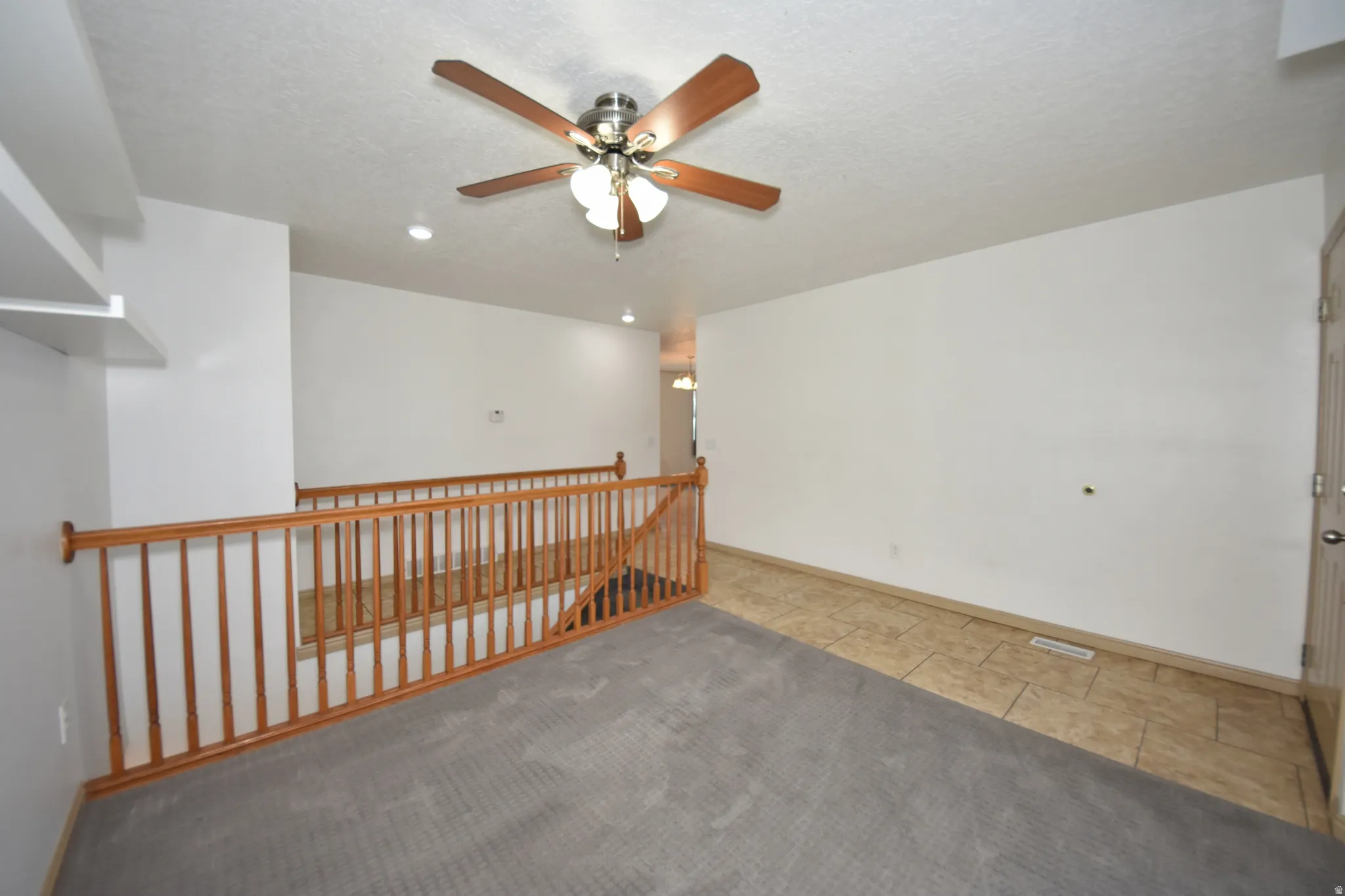 Carpeted room featuring a ceiling fan with light fixture and recessed lighting