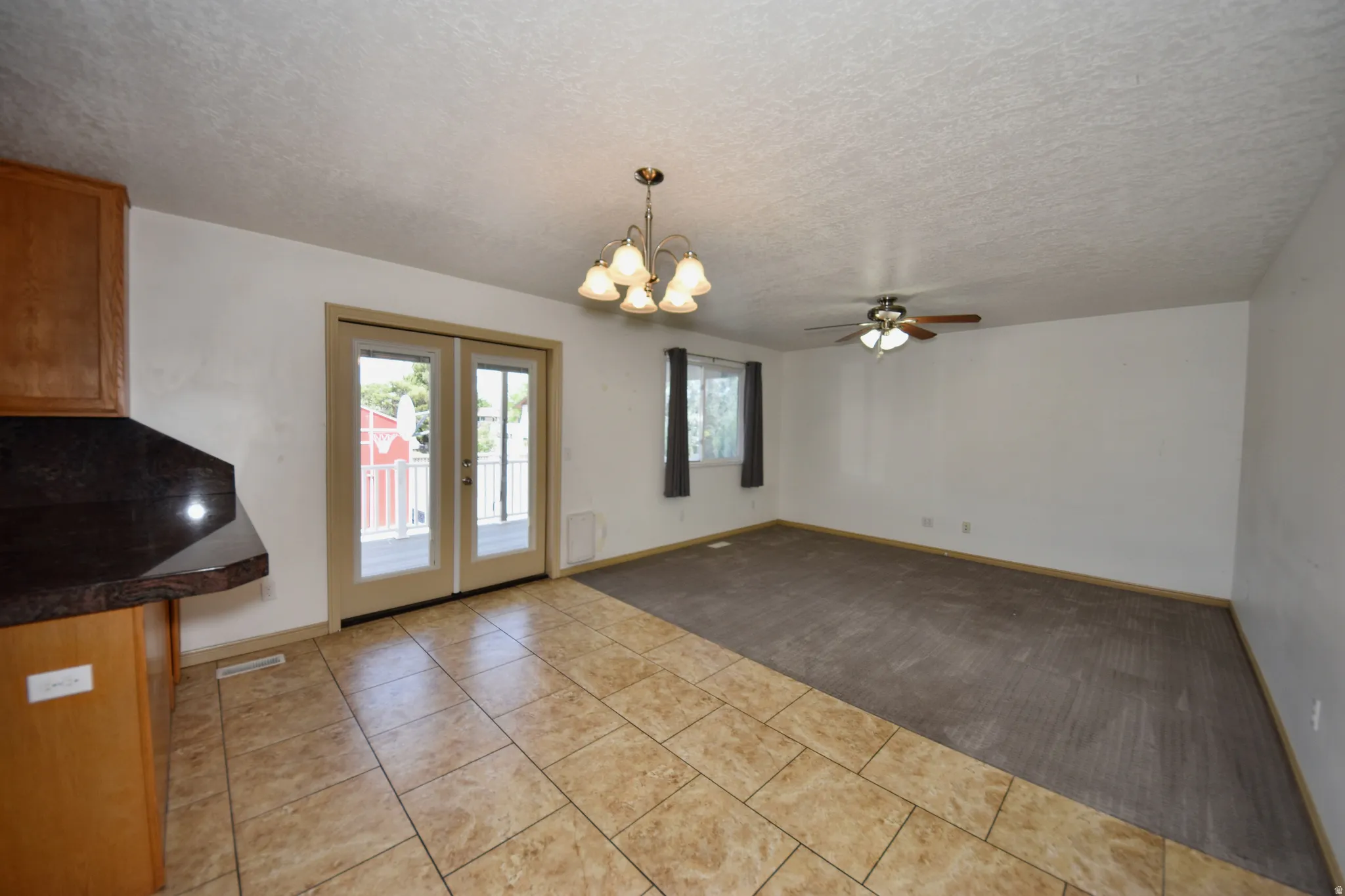 Open-concept living area featuring a tile-floored dining space and carpeted living room