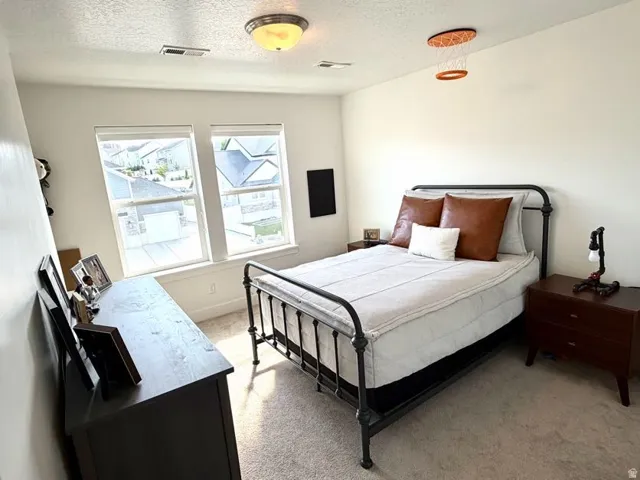 Bright room featuring two windows, recessed lighting, and neutral-toned carpeting