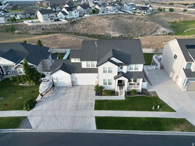 Contemporary two-story residence with a dark shingle roof and white vertical siding accents