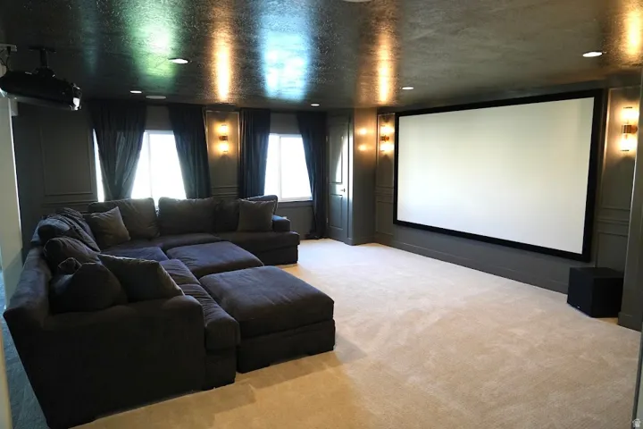 Theater room featuring a large projection screen, recessed lighting, and wall sconces and amazing sound system with subwoofer!