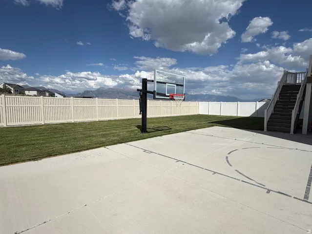 Expansive concrete patio with basketball court markings and an adjustable hoop