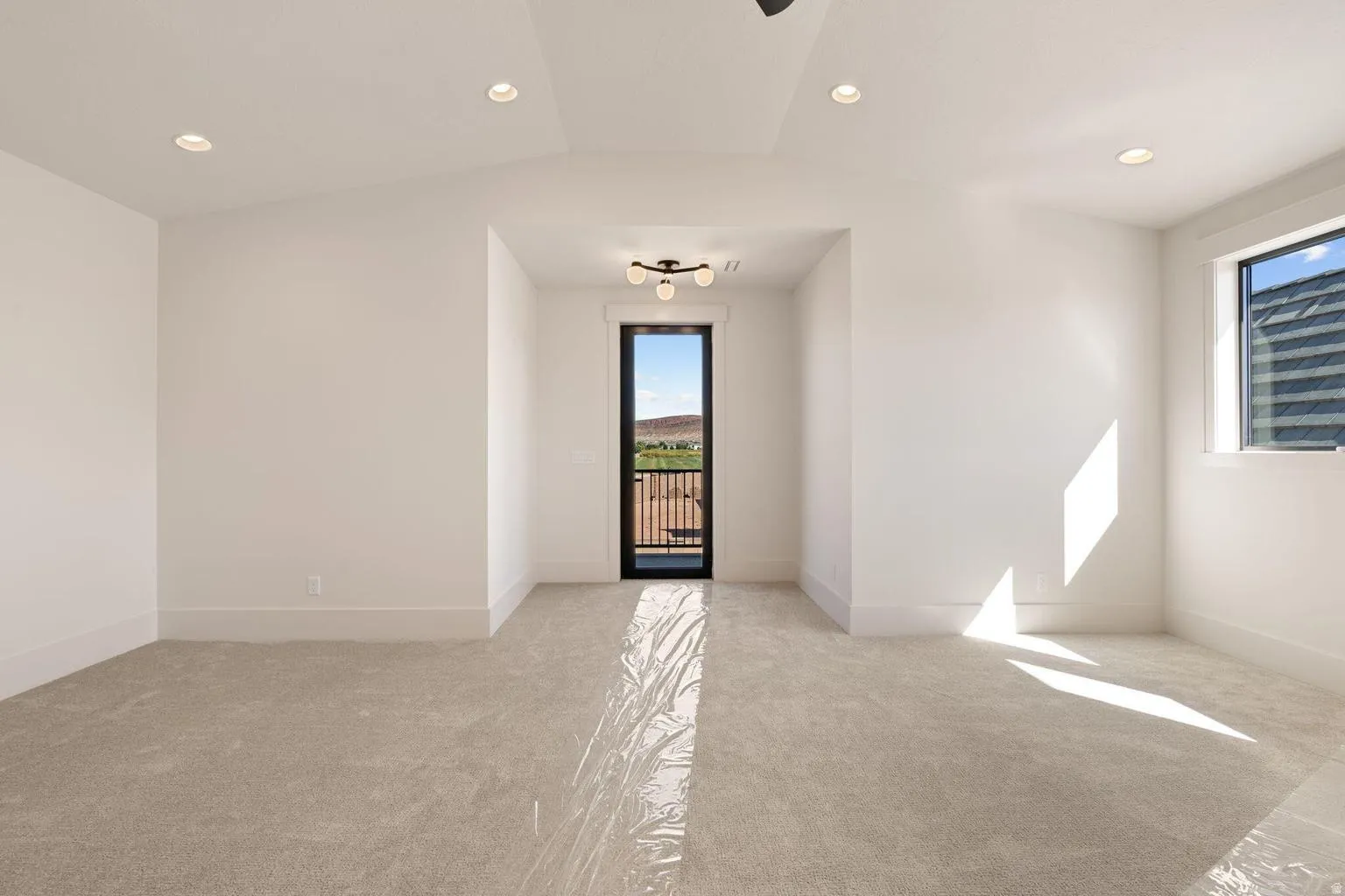 Carpeted room featuring a ceiling fan, recessed lighting, and a full-height glass door opening to a balcony with a wrought iron railing