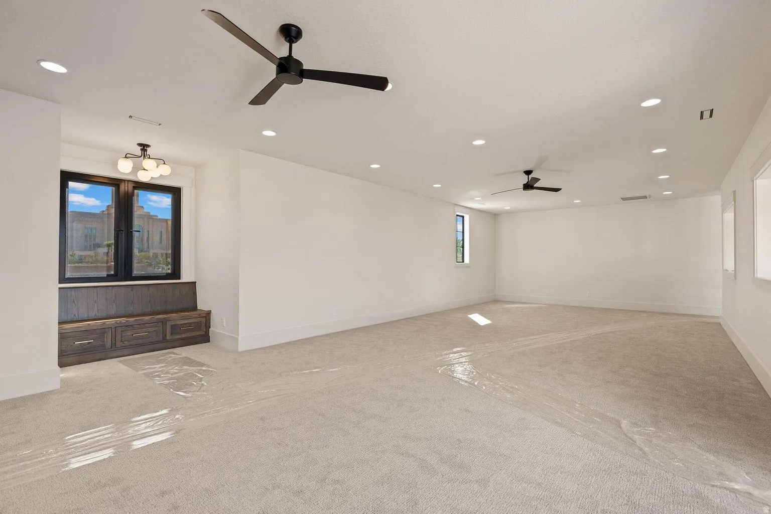 Spacious room featuring neutral carpeting and white walls