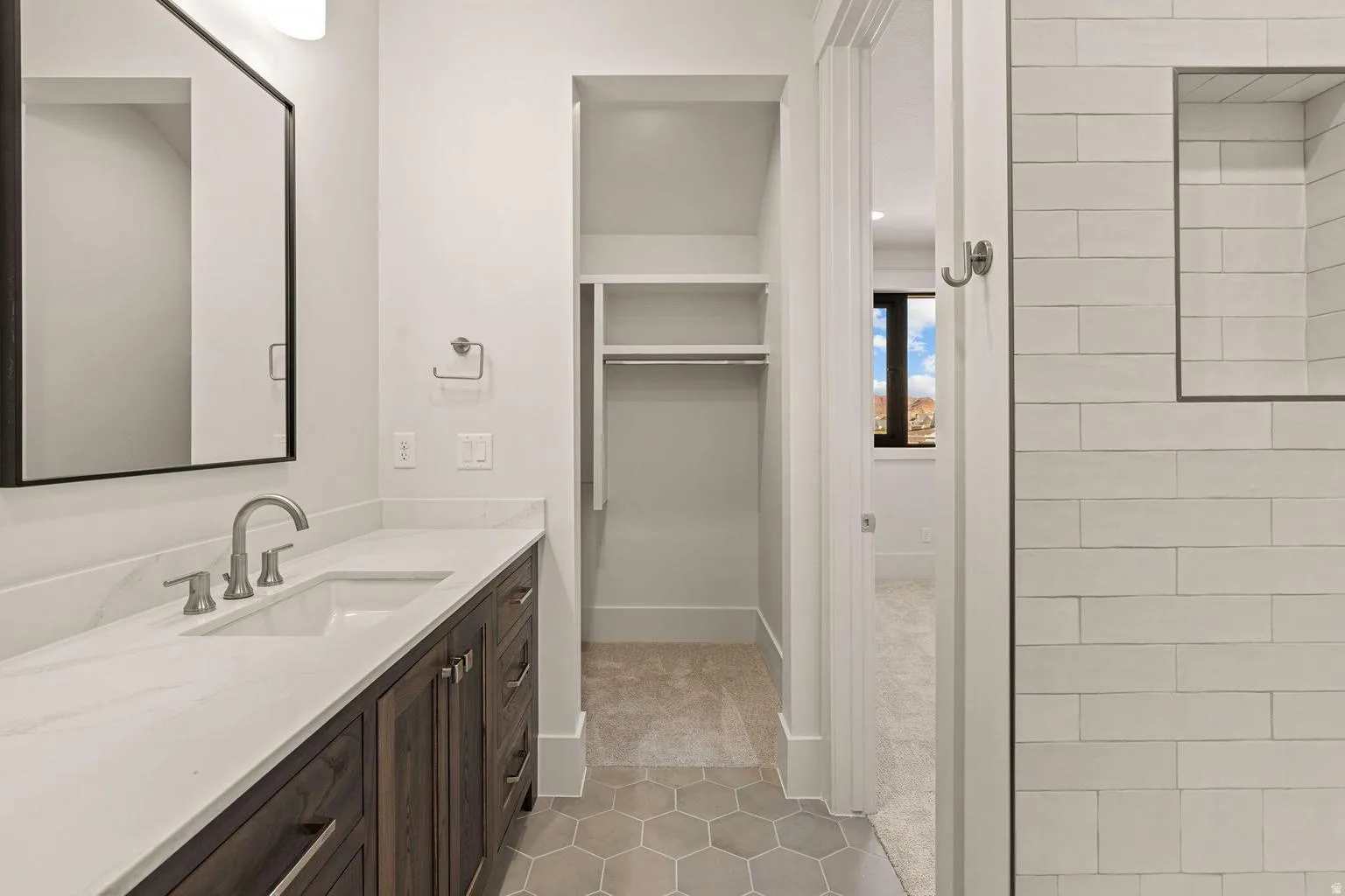 Bathroom vanity featuring a quartz countertop, integrated rectangular sink, and brushed nickel faucet