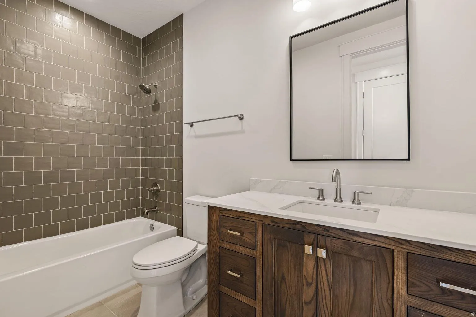 Bathroom vanity with a white countertop and undermount sink, complemented by a wood-finish cabinet