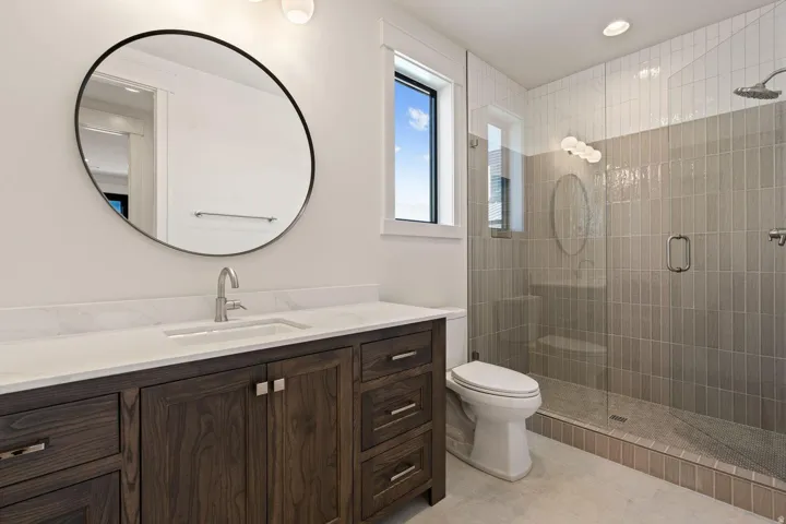 Modern bathroom featuring a wood-finish vanity with a white countertop and integrated sink