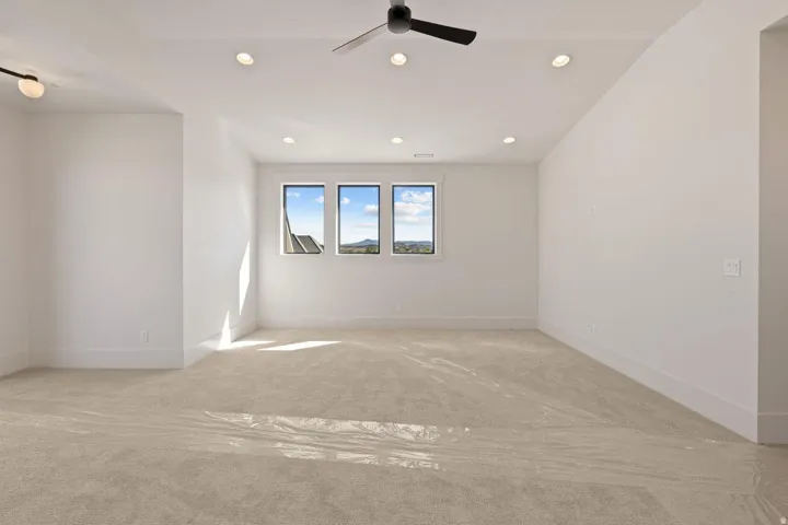 Spacious room featuring neutral carpeting and white walls