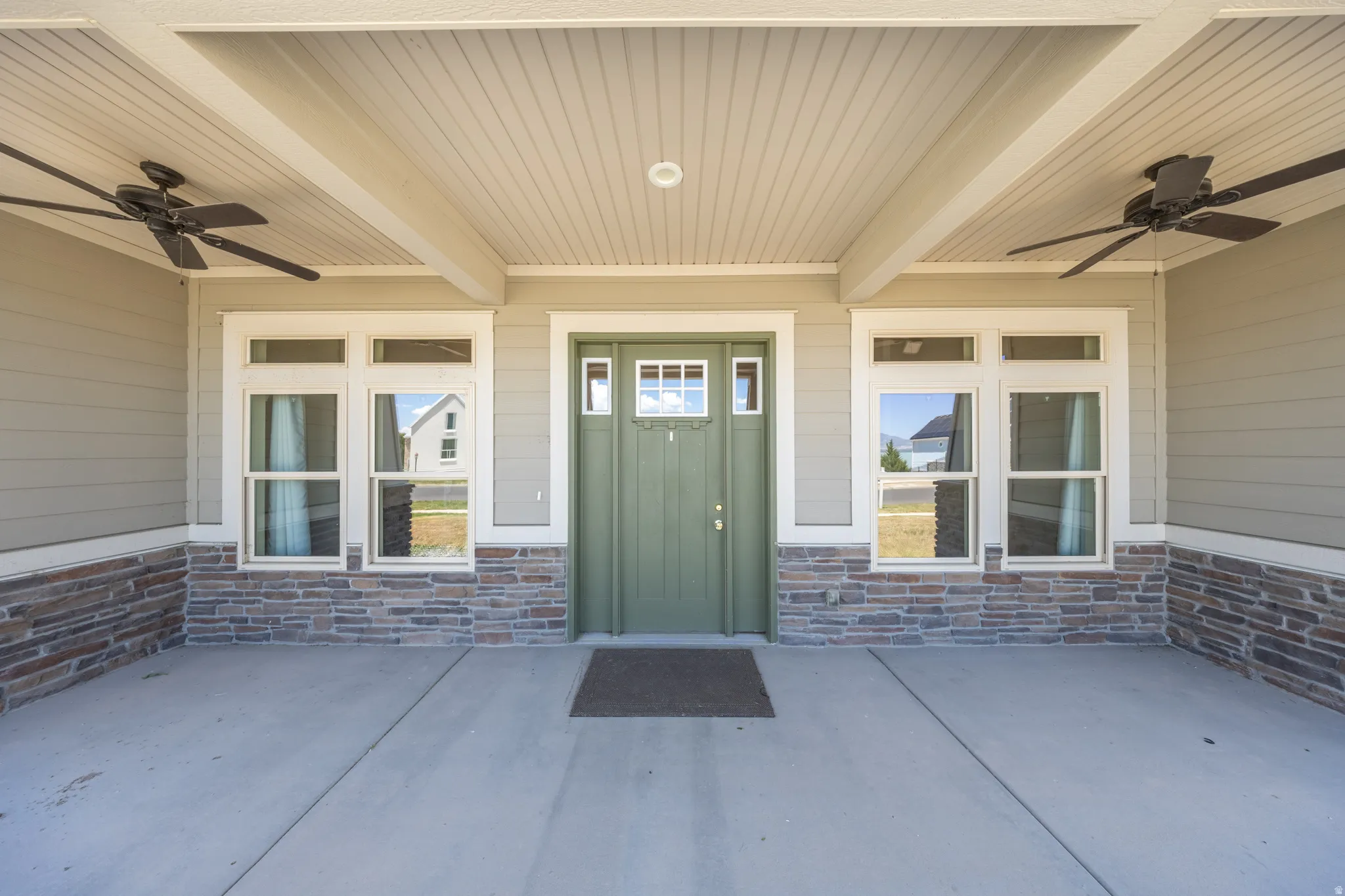 Exterior covered porch entry features ceiling fans to provide a breeze as you sit in the evening looking over the lake.