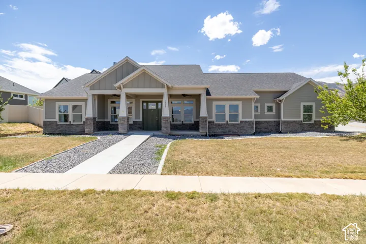 Ranch-style residence featuring a prominent covered entryway with white columns and a dark green door