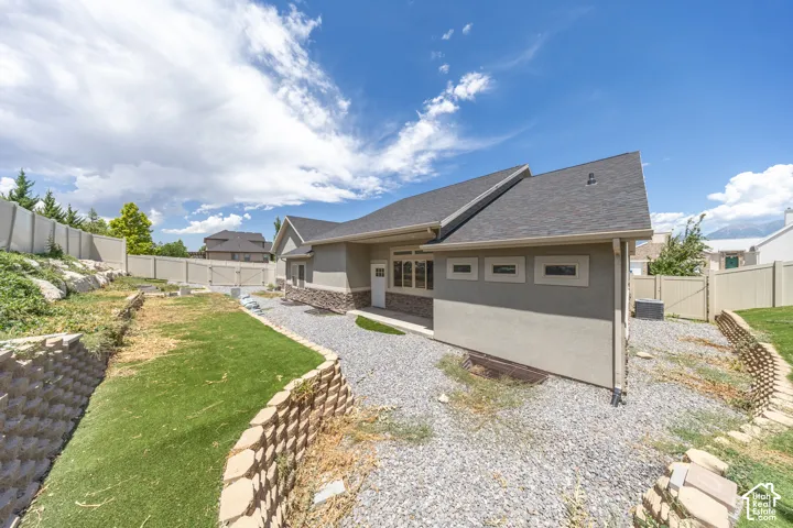 View of back yard from SW corner. Terraced yard with retaining wall. Covered patio.