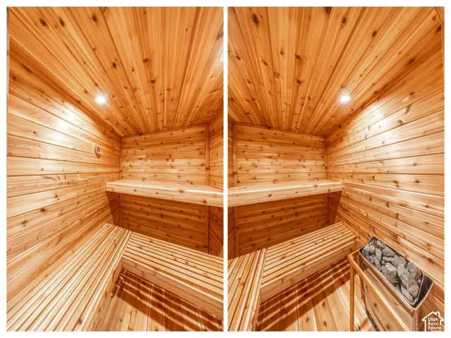 Dedicated sauna featuring wood-paneled walls and ceiling, multi-level slatted wood benches, and an integrated sauna heater with stones.