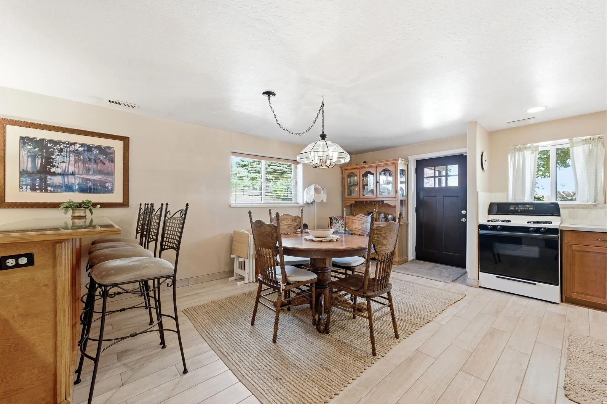 Lower level walk Open-concept space featuring light-toned wood-finish flooring and a central dining area