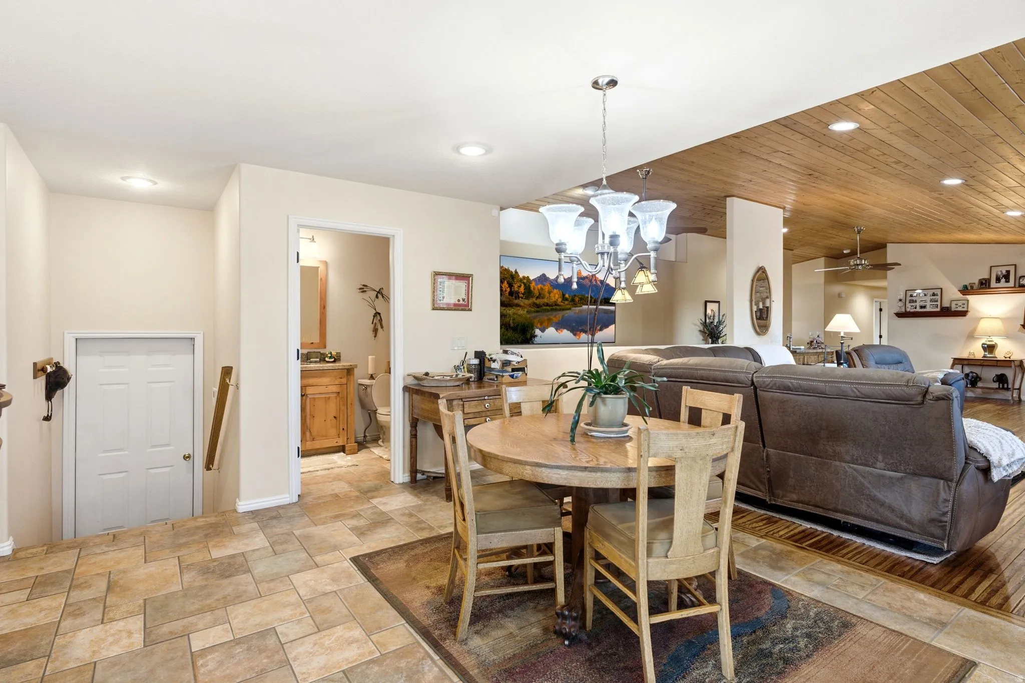 Open-concept living space with multi-toned tile flooring, wood-finish flooring, a wood-paneled ceiling, and recessed lighting