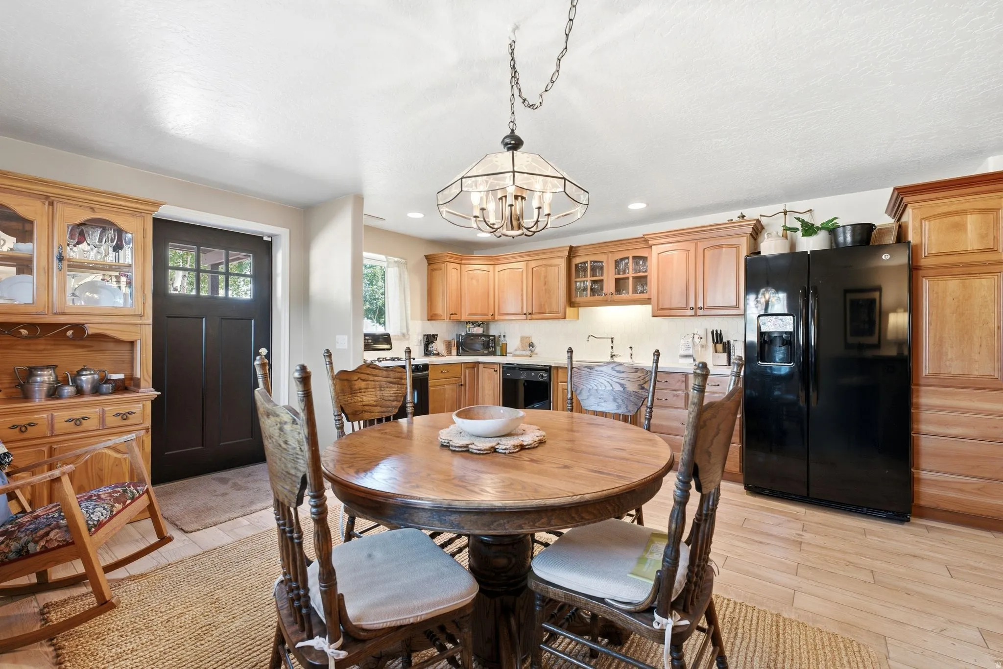 Lower Level Well-appointed kitchen featuring wood-finish cabinetry, black appliances, recessed lighting, and light wood-finish flooring