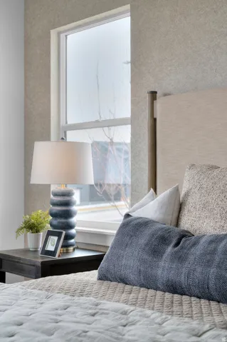 Bedroom featuring a large window, textured wall finish, and an upholstered headboard