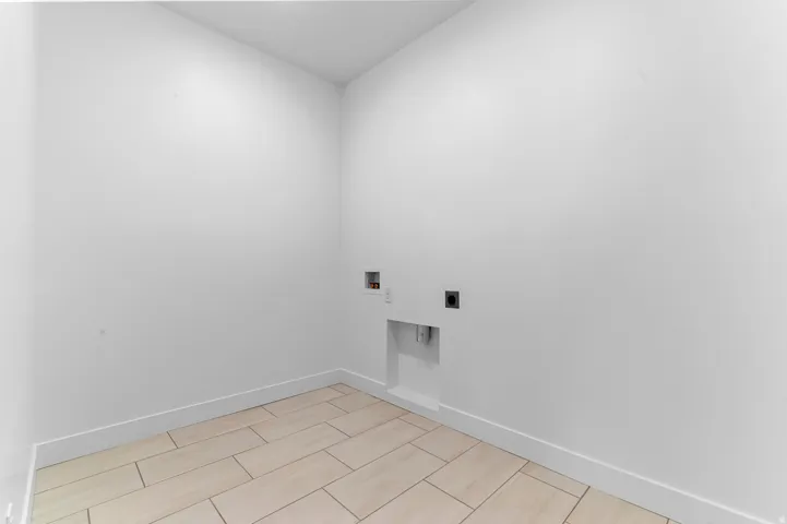 Utility area featuring light-toned plank-style flooring, white walls, and white baseboards