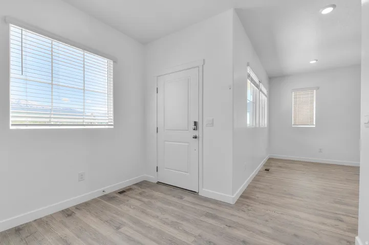 Entryway area featuring wood-finish flooring, white walls, and a recessed light fixture