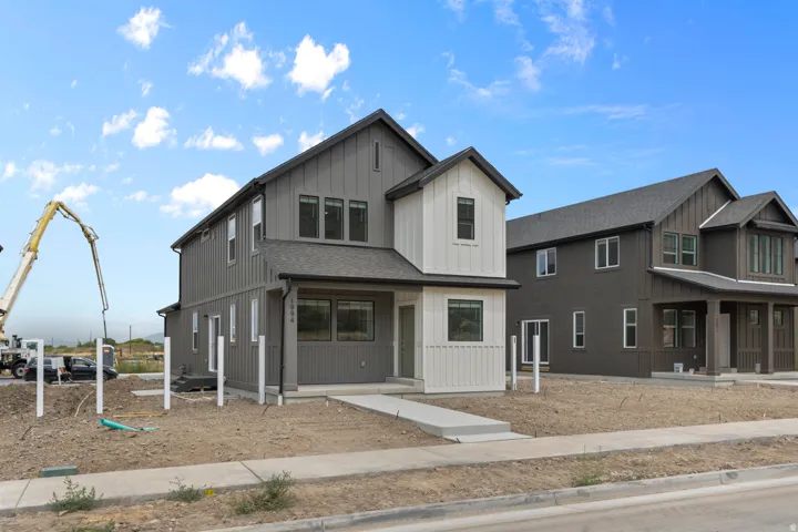 Contemporary two-story residence featuring a striking vertical board and batten siding in a two-tone gray and white color scheme
