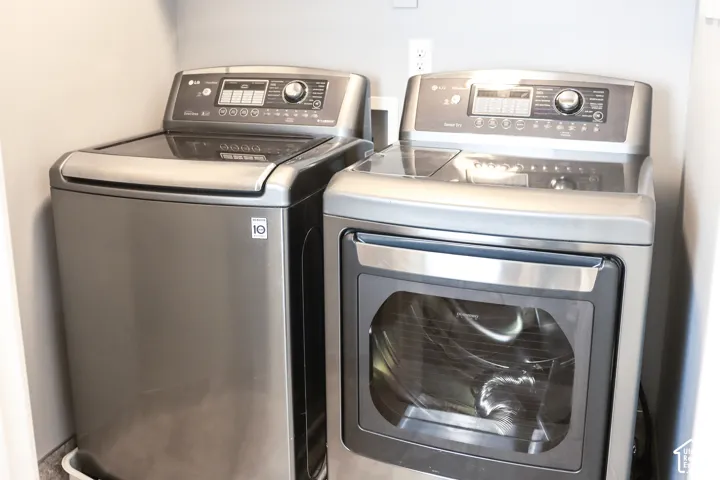 Dedicated laundry area featuring a top-load washer and a front-load dryer, both with stainless steel finishes