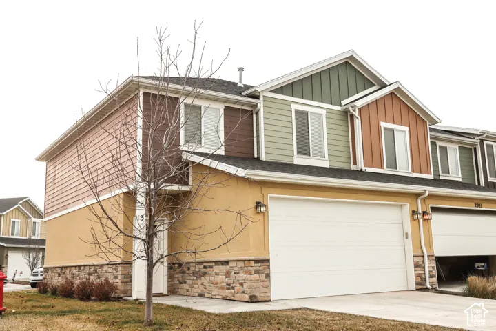 Multi-level townhome featuring a stone and stucco base with varied siding on upper levels