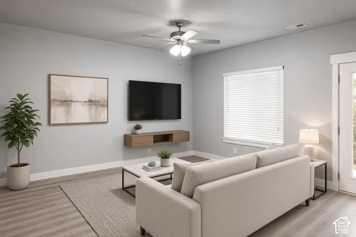 Wood-finish flooring throughout, ceiling fan with integrated lighting, window with blinds, and white door with opaque glass panel