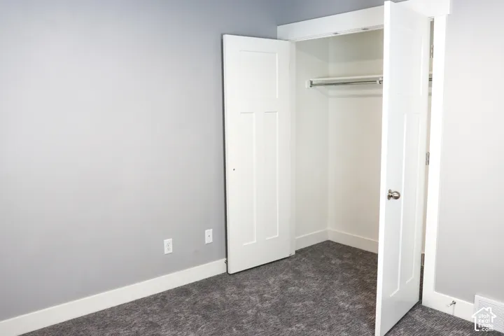 Recessed closet featuring bi-fold doors, white trim, and integrated hanging rod