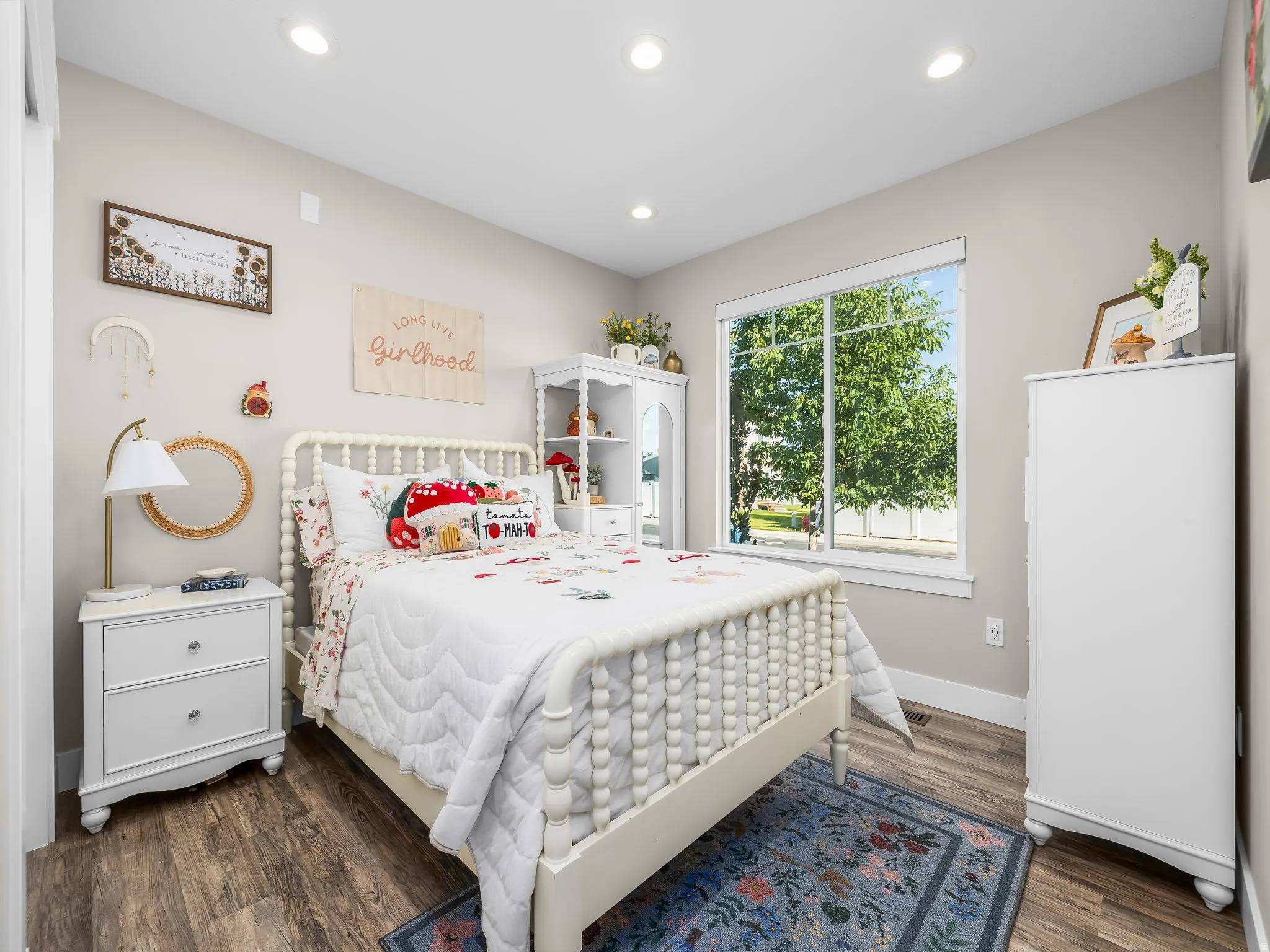 Bright room with wood-finish flooring, recessed lighting, and a large window