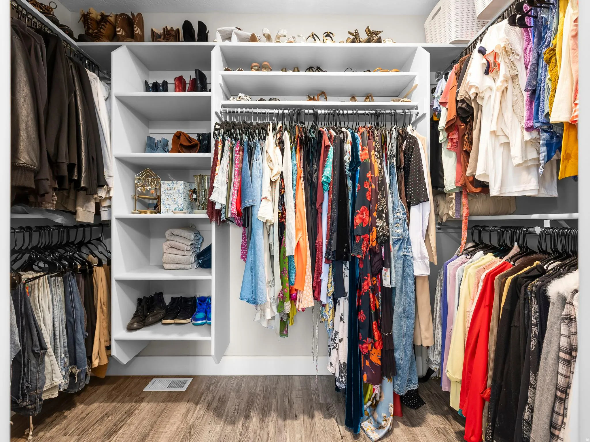 Custom closet system featuring wood-finish flooring