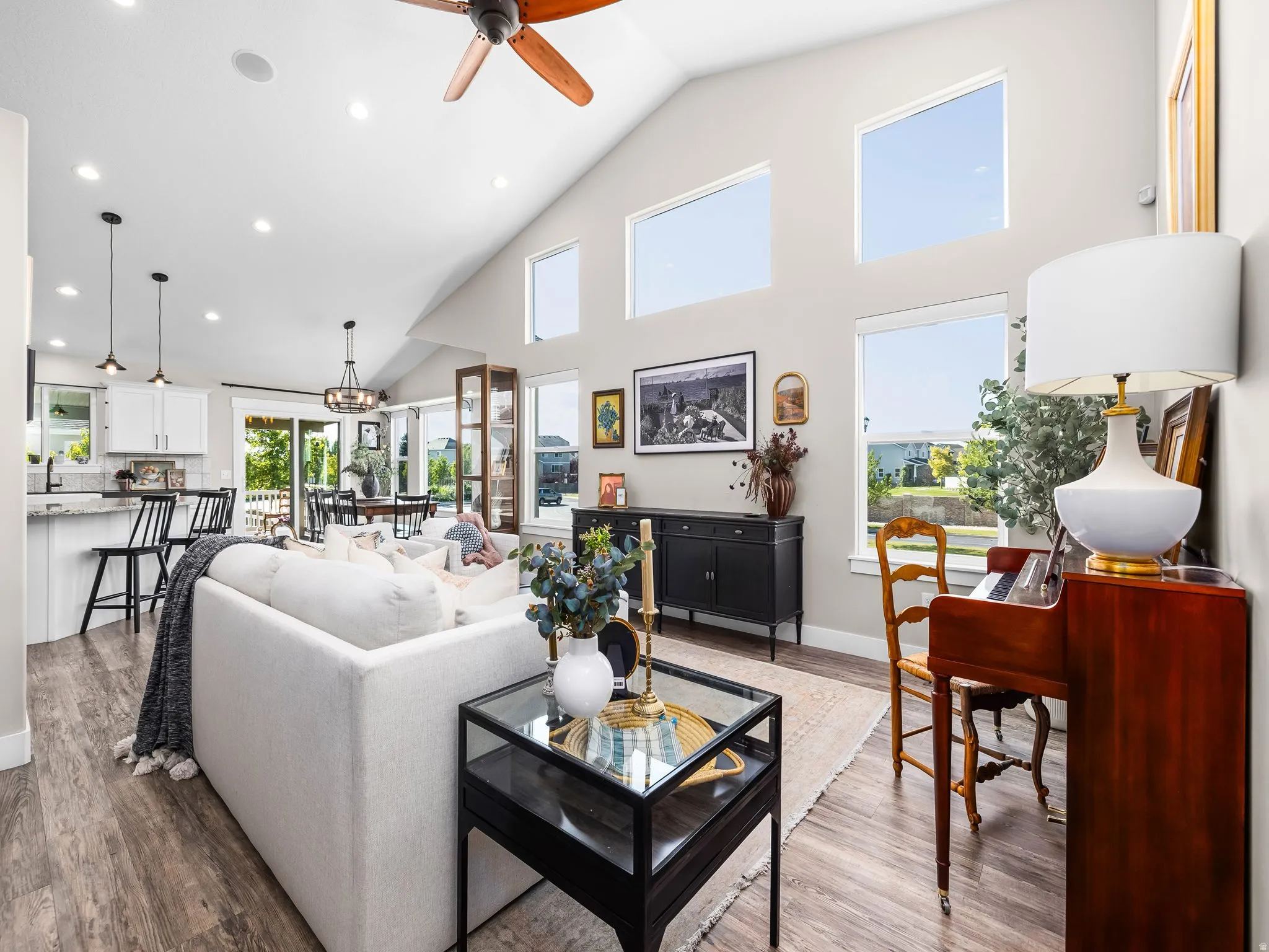 Vaulted great room featuring wood-finish flooring, recessed lighting, and a ceiling fan