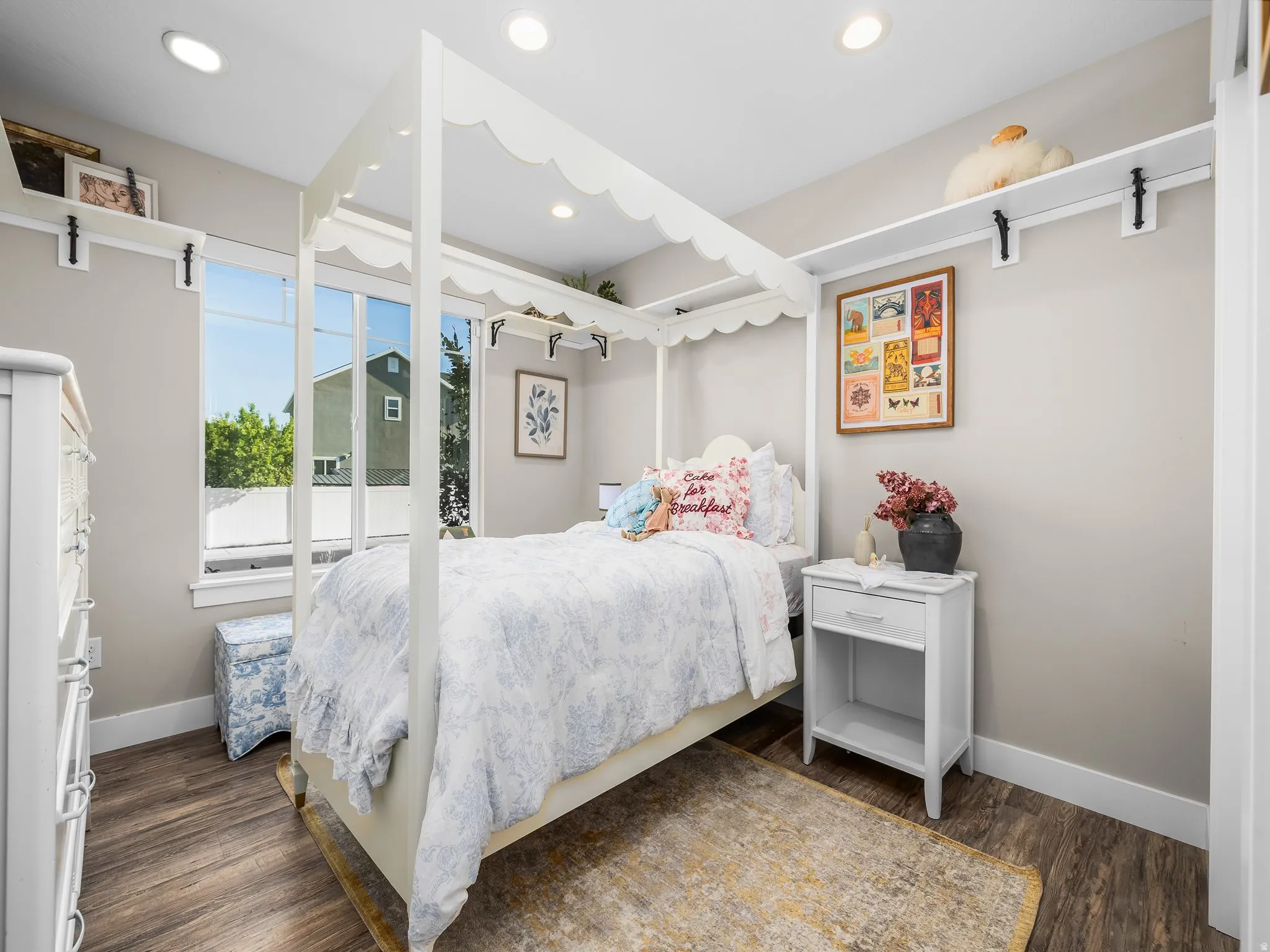 Spacious bedroom featuring wood-finish flooring, recessed lighting, and a large window