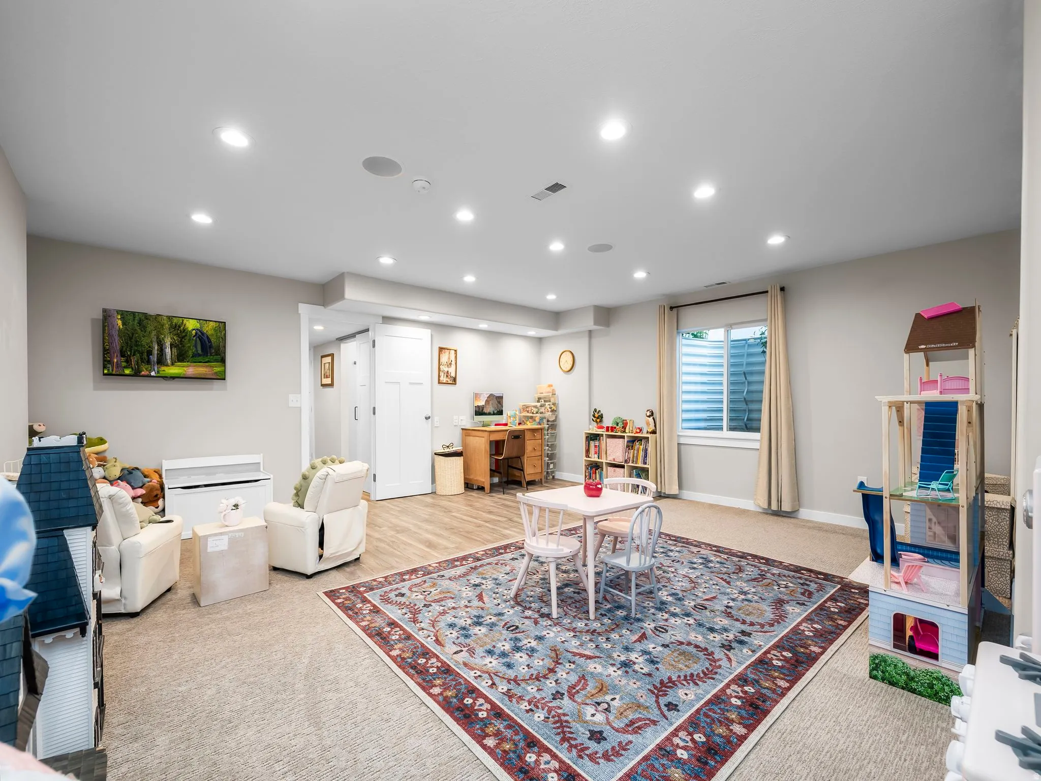 Spacious interior featuring recessed lighting, a window with blinds, and a combination of carpet and wood-finish flooring