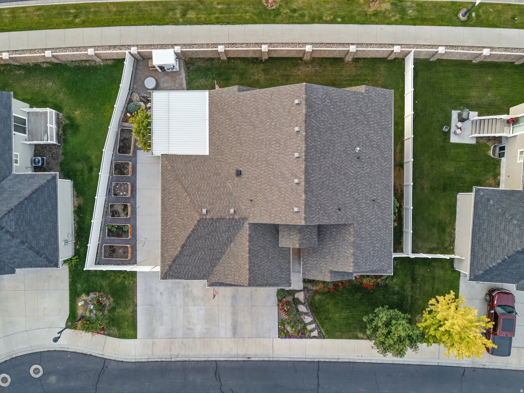Aerial perspective showcasing a property with a multi-gabled roofline and a concrete driveway