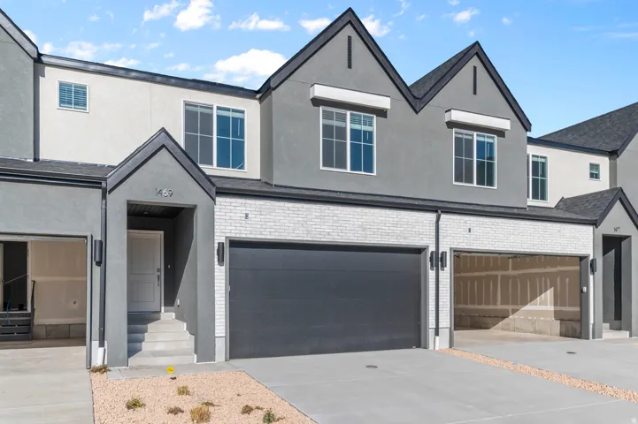 Contemporary townhome exterior featuring a stucco and white brick facade